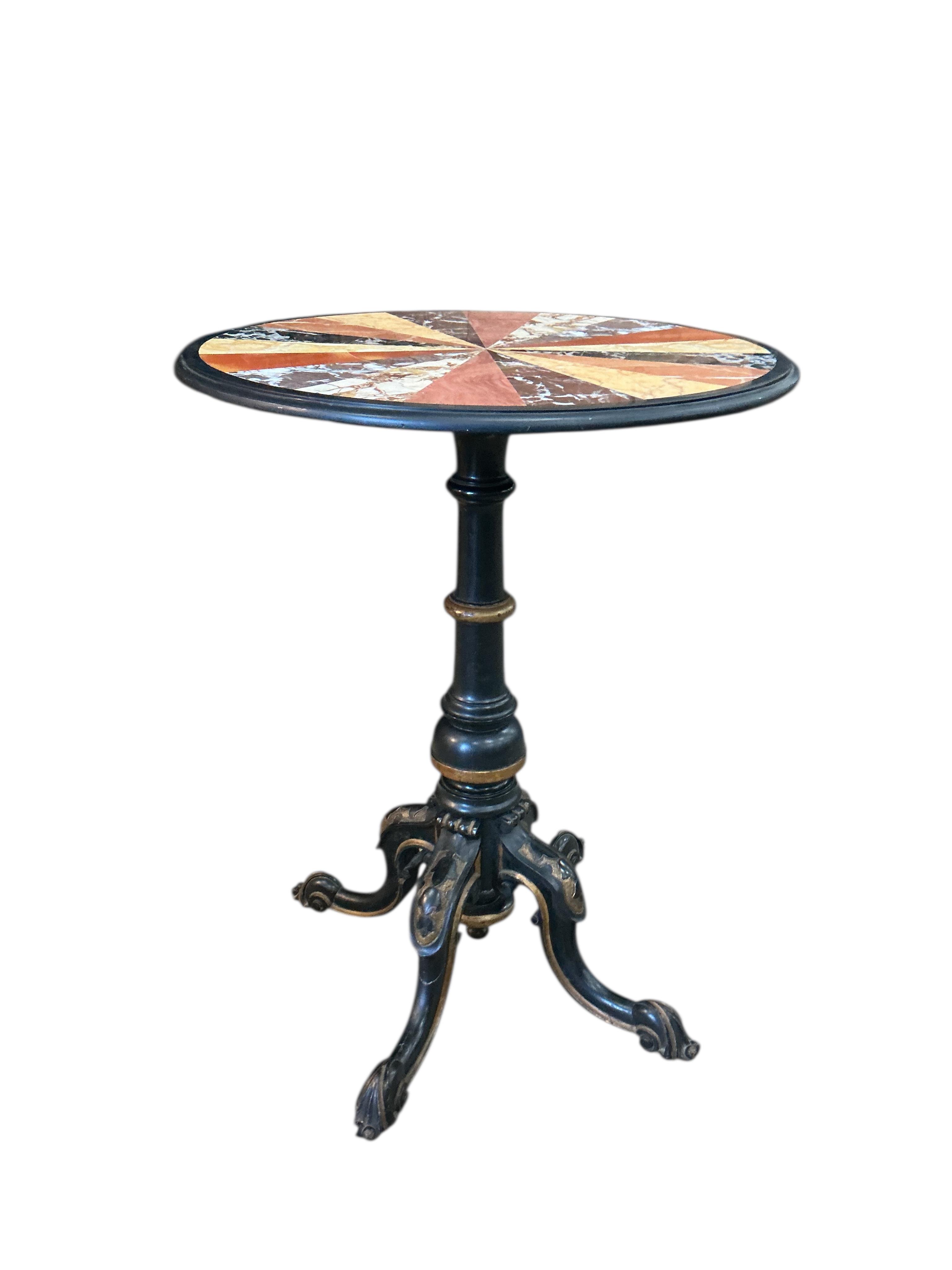 A circular specimen marble occasional table on a Victorian ebonised tripod base, diameter 53cm, height 69cm